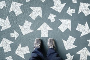 person standing in front of arrows in different directions