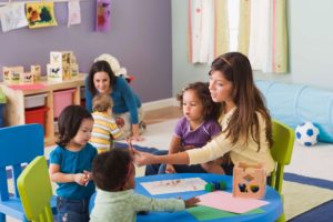 Two mothers doing crafts with children at playdate